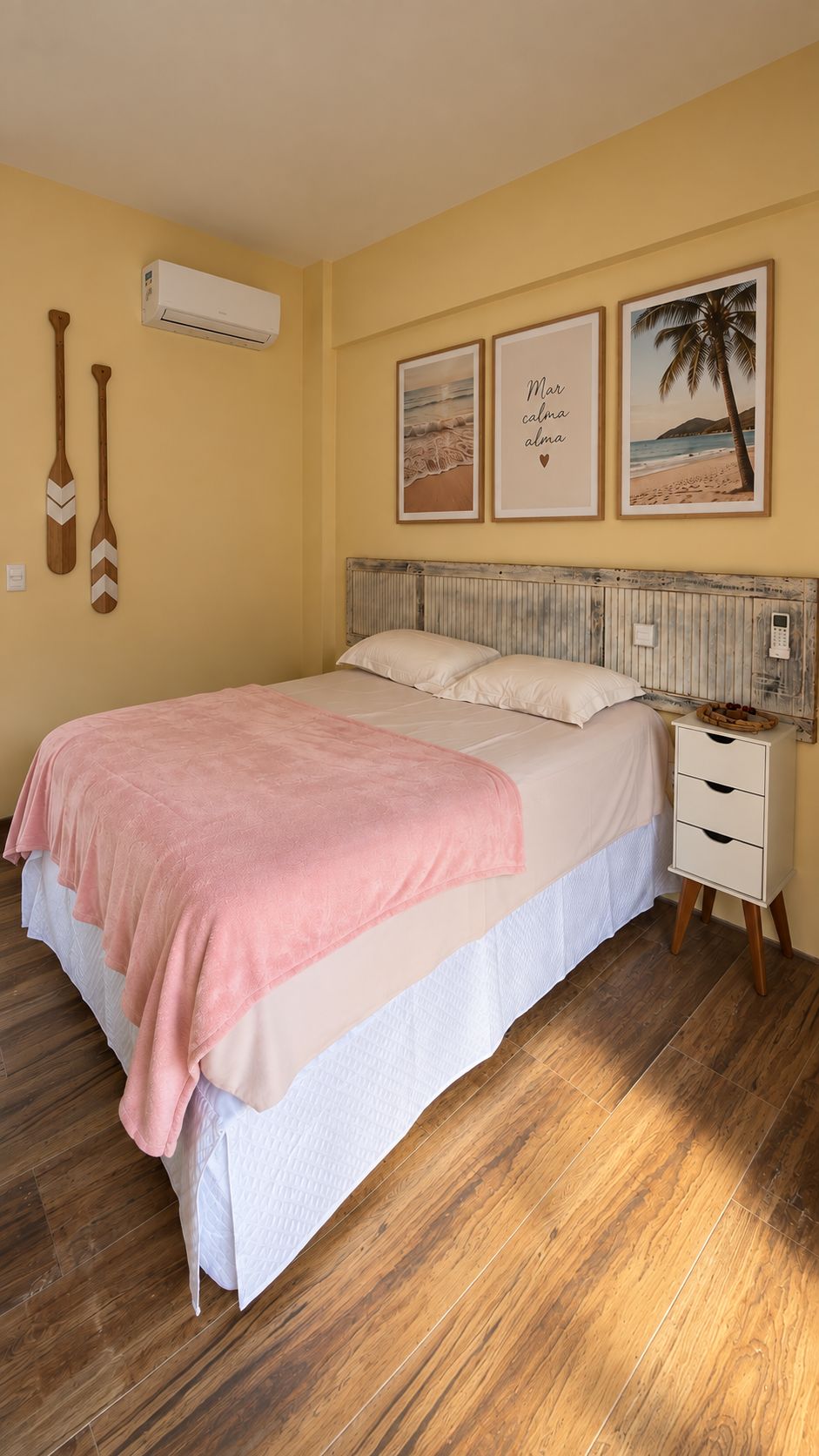 Une chambre à coucher avec un lit, une table de chevet, un plancher en bois et des décorations murales.