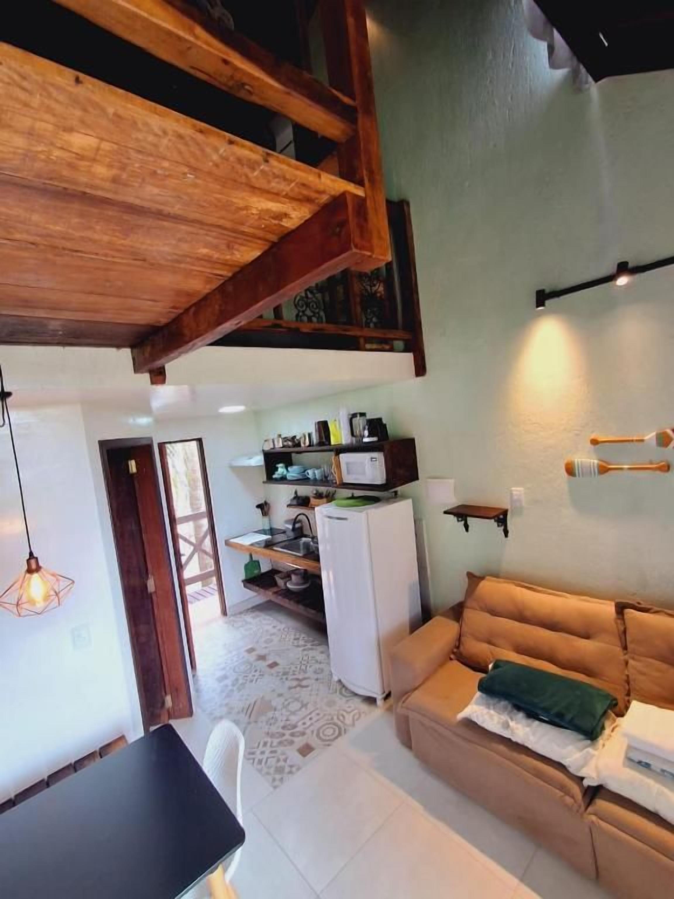 Un espacio de sala acogedor con sofá, una mesa de comedor y una cocina al fondo.