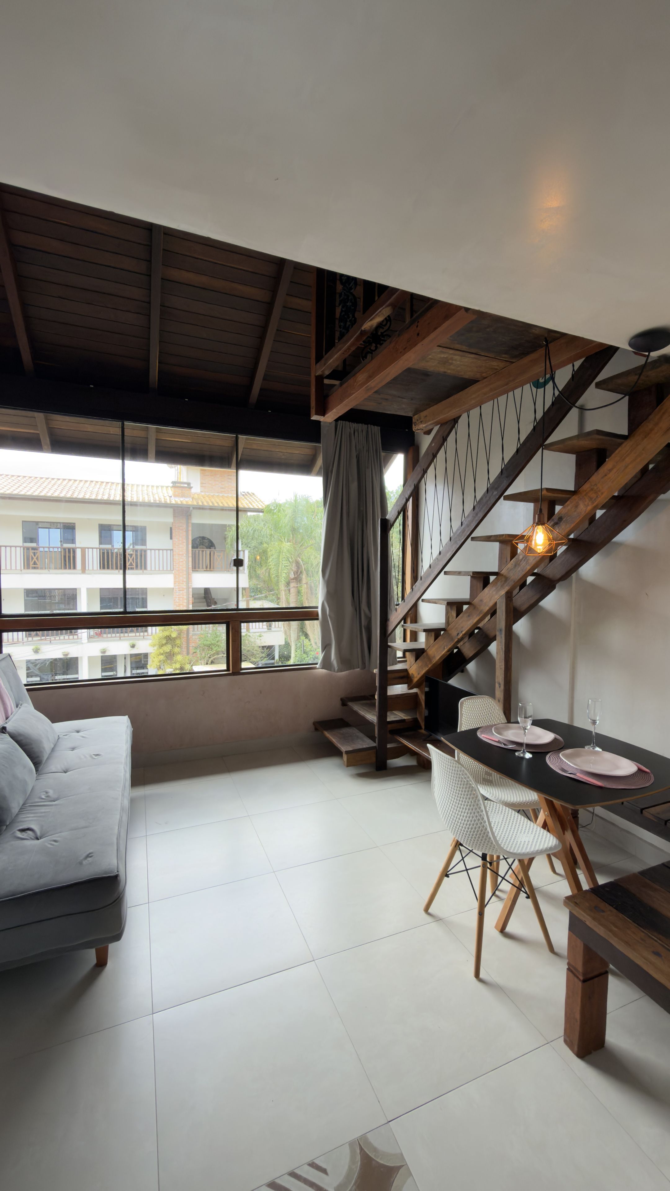 A modern interior with a staircase, a dining area, and a sofa.