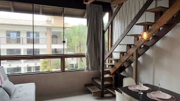 A modern interior with a staircase, a dining area, and a sofa.