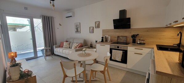 Cozinha moderna com área de refeições, um sofá e vista para o exterior.
