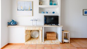 Uma sala de estar moderna com televisão, estantes e objetos decorativos.