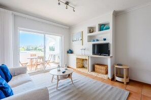 Ein modernes Wohnzimmer mit einer Couch, einem Fernseher und einem Kamin.