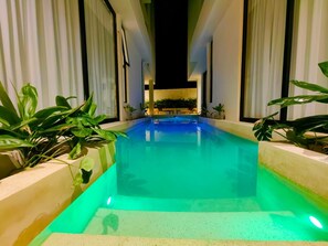 An indoor swimming pool with a view of the night sky, surrounded by plants and a modern architectural design. - Koom Tulum, Your Perfect Getaway to Experience the Riviera Maya (Pet-Friendly) (Tulum)