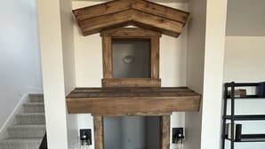Avoin, loft-tyylinen huone, jossa on puinen kattorakenne, sisäänrakennettu penkki ja kirjahylly.