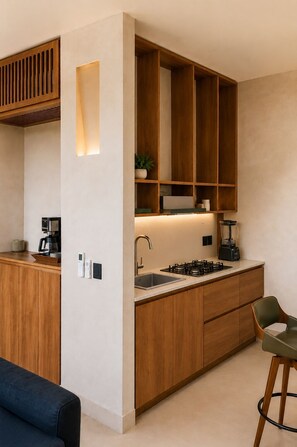 Eine moderne Küche mit Holzausstattung, Einbauherd und einer Kaffeemaschine.