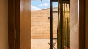 A room with a bed, a window, and a view of a building. - Olivo Mío Apartment (La Paz)