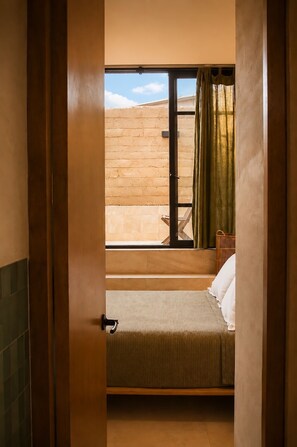 Ein Zimmer mit einem Bett, einem Fenster und Blick auf ein Gebäude.