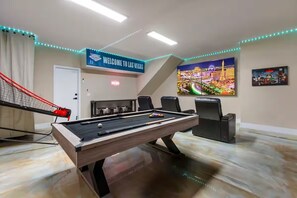 A pool table with a cue ball, a pool table, and a welcome sign in a room with a view of a cityscape. - Luxury Henderson Pool Retreat  Heated Pool  Near Las Vegas Strip (Henderson)