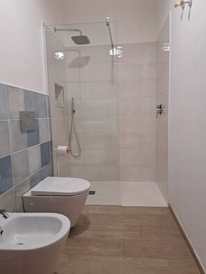 Kylpyhuone, jossa on suihku, wc ja bidee.