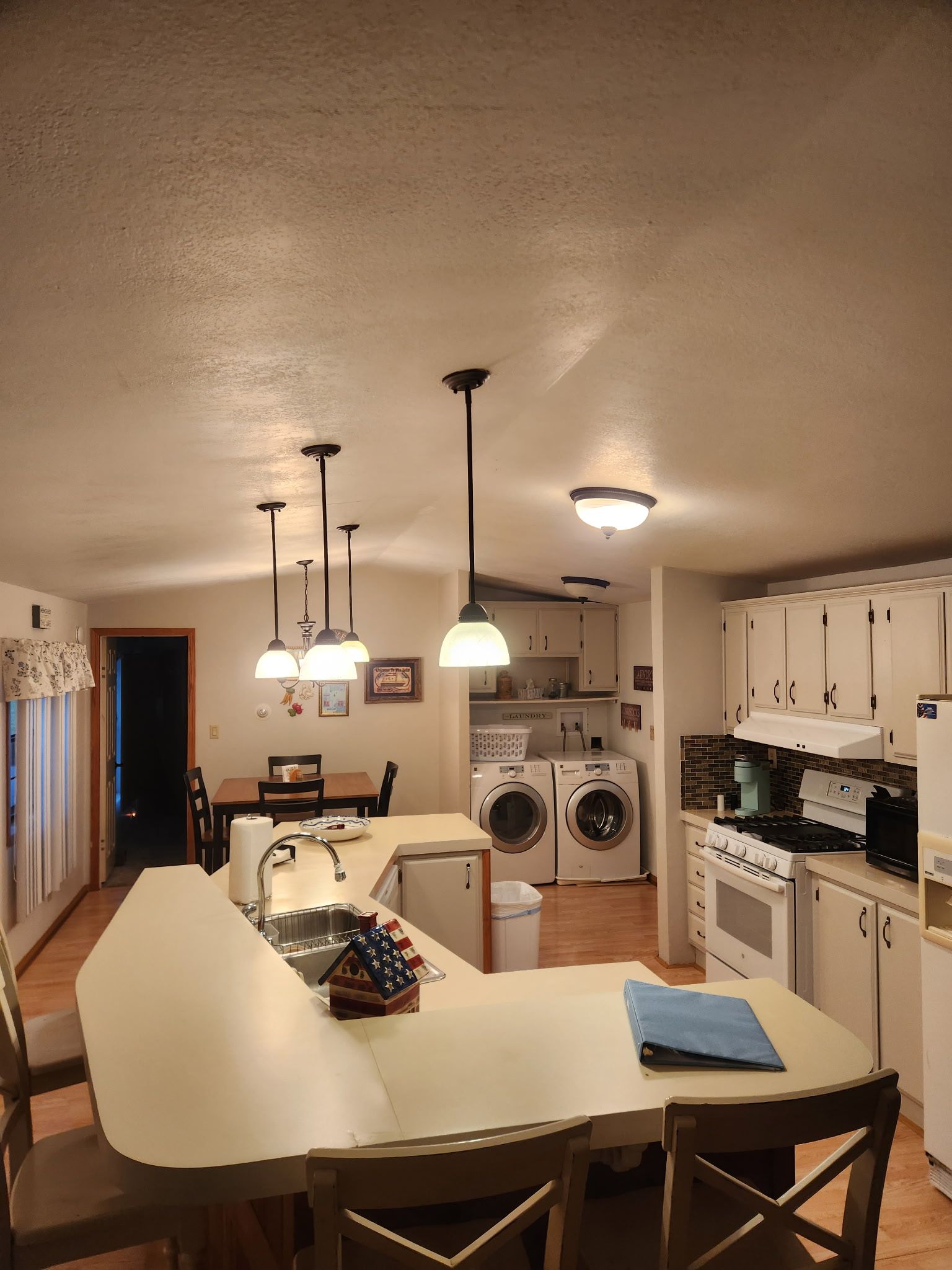 Una cocina compacta con comedor, lavadora y estufa.