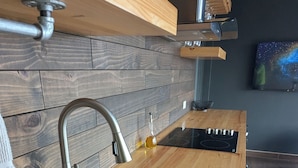 A modern kitchen with a wooden countertop, stainless steel sink, and a built-in oven. - 1 bedroom guesthouse with volcano views throughout the home in Juayua (Juayua)