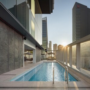 Ein modernes Gebäude mit Pool, Außenbereich und Blick auf die Stadtlandschaft.