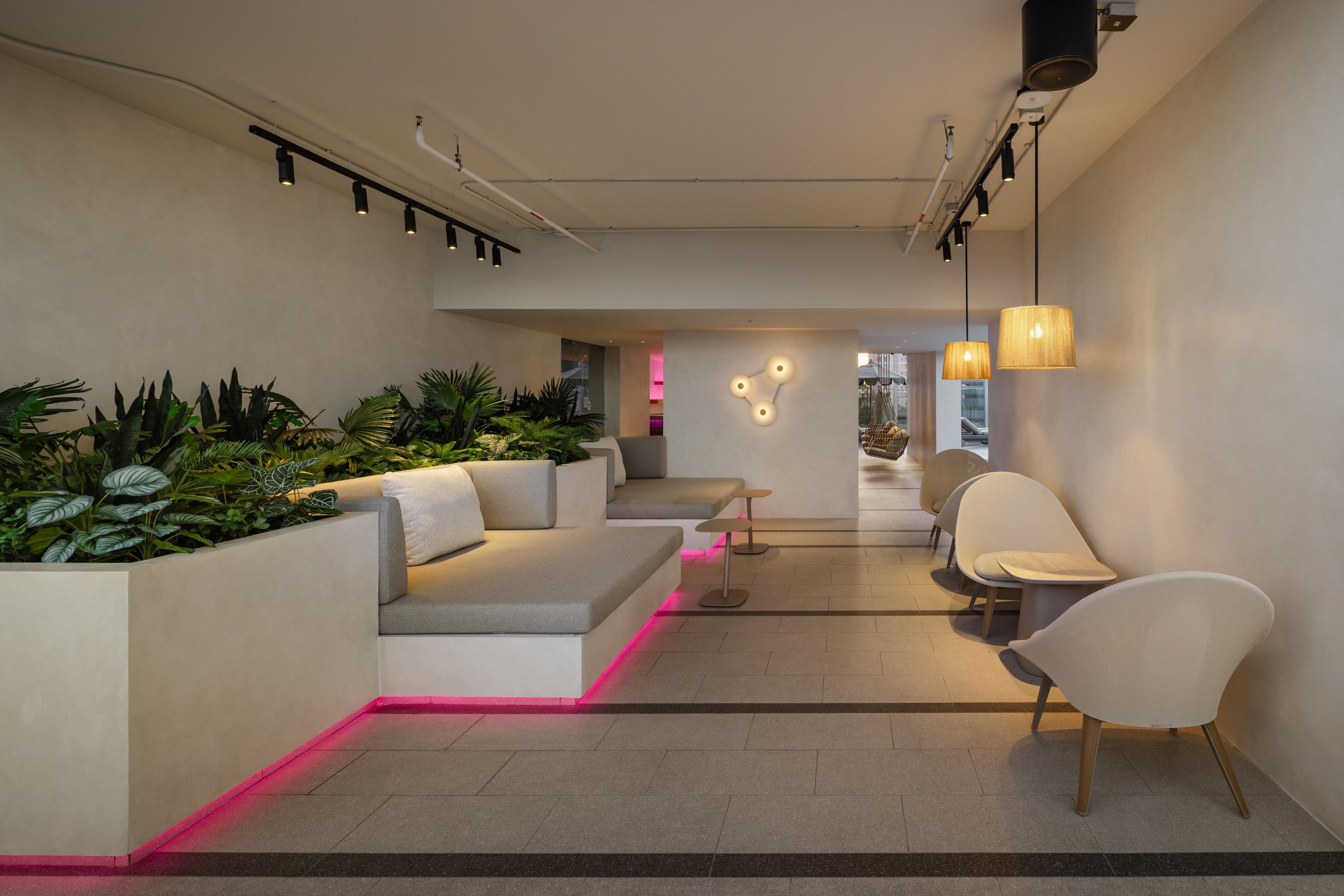 Een modern interieur met een zithoek, planten en uitzicht op het omliggende landschap.