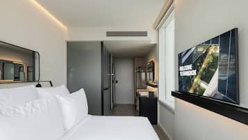 Een hotelkamer met een bed, een televisie en een badkamer.