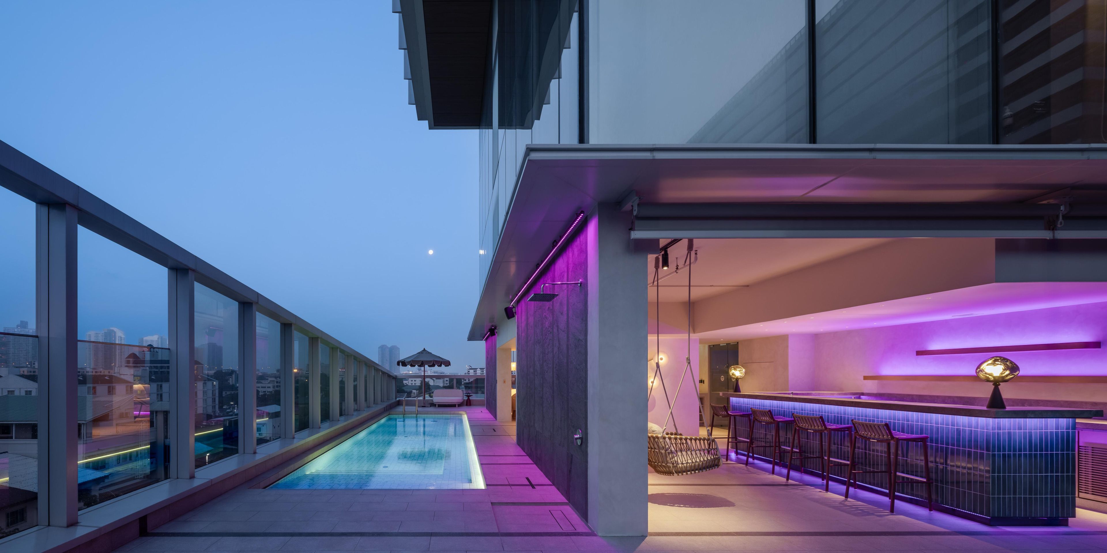 Un bar a la terrassa amb piscina, zona de seients i vistes a la ciutat.