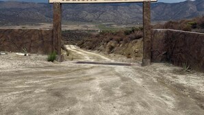 A sign with 'RANCHO MELING' written on it, with a mountainous landscape in the background. - Rancho Meling Mountain Cabin #3 with Pool and Views (Baja California)