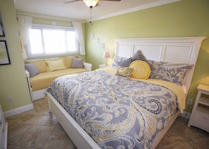 A bedroom with a bed, bedside table, and a window with curtains. - Beachfront Condo, Gulf View, Balcony, Beach Chairs, Heated Pool, Jacuzzis (Panama City)