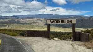 Une enseigne pour le Rancho Meling, avec un paysage montagneux en arrière-plan.