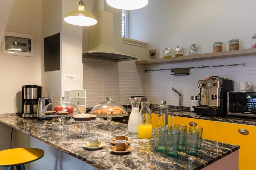 A kitchen with a marble countertop, coffee maker, toaster, and breakfast items.