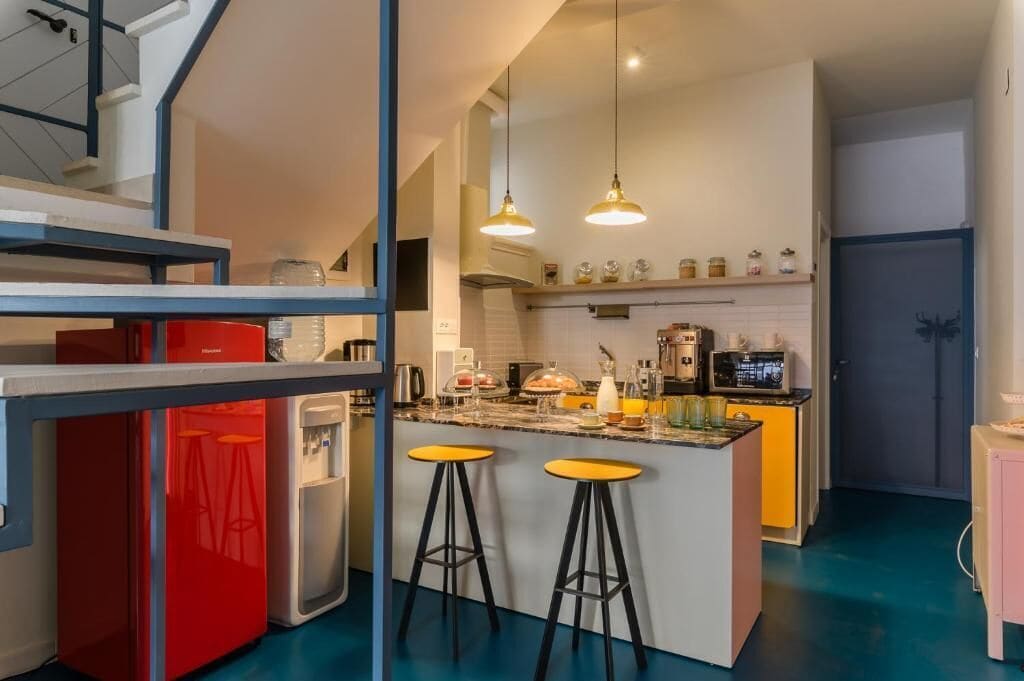 Eine moderne Küche mit Kochinsel, Barhocker und Kühlschrank.