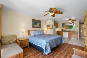Ein Schlafzimmer mit Bett, Nachttischen, einer Schlafcouch und Blick zur Küche.