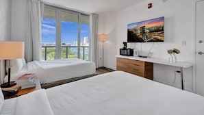 Une chambre d’hôtel avec deux lits, une télévision, un bureau et une fenêtre donnant sur la ville.