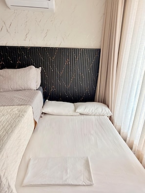 A hotel room with a bed, pillows, a headboard, and a window with curtains. - 🌴 Caribbean Resort-Style Paradise: Ocean Views, Pools, and Relaxation in Santa Marta (Santa Marta)