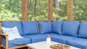 A blue sofa with cushions, a wooden table, and a game board.