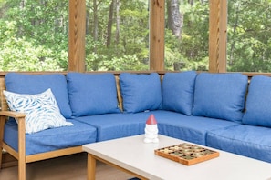 A blue sofa with cushions, a wooden table, and a game board.