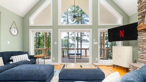A spacious living room with a large couch, a coffee table, and a view of a deck with outdoor furniture.