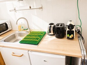 Eine Küche mit Spüle, Geschirrgestell, Wasserkocher, Toaster und Mixer.