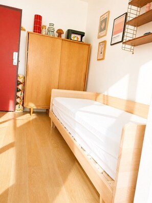 Ein Zimmer mit einem Bett, einem Schrank und einer roten Tür.