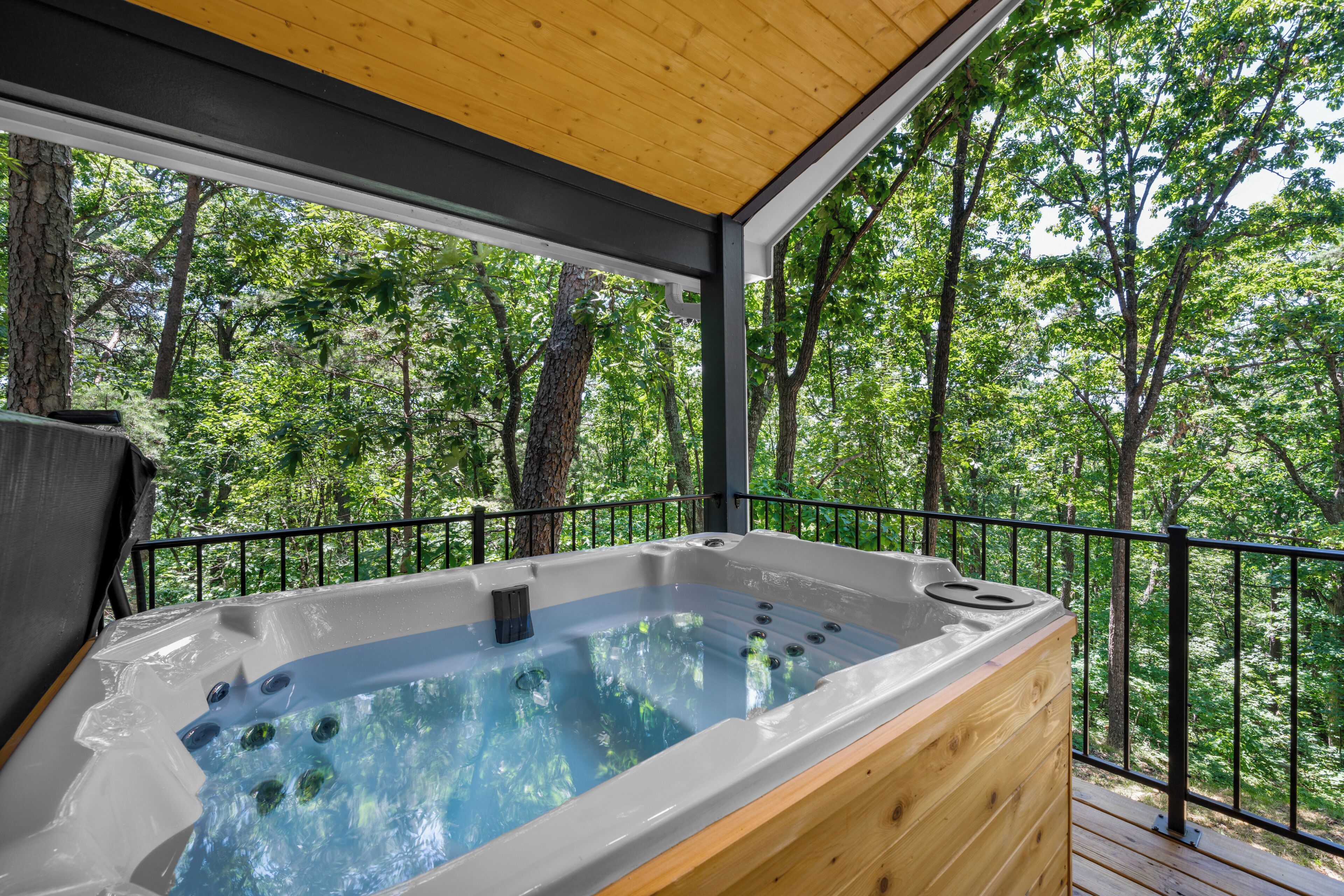 Un bain à remous sur une terrasse avec vue sur la forêt.