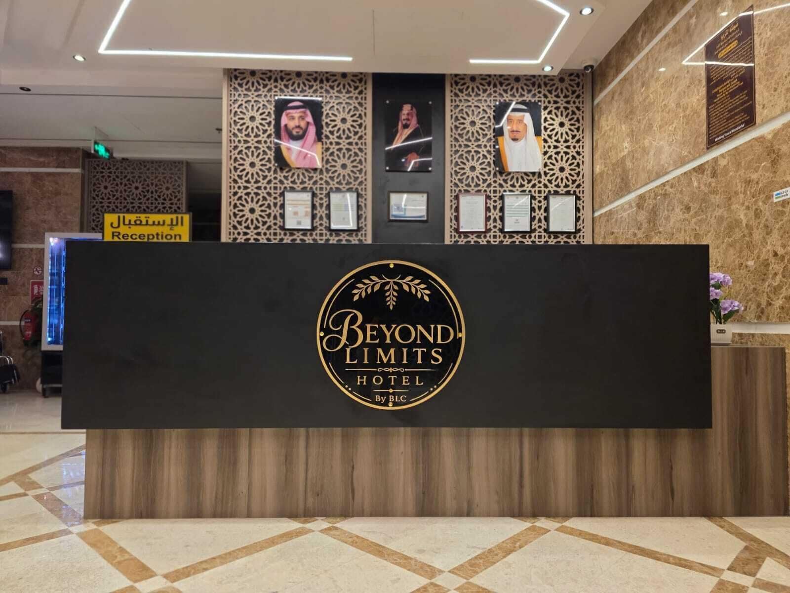 A reception desk with a logo for 'Beyond Limits Hotel' and a sign for 'Reception' in Arabic.