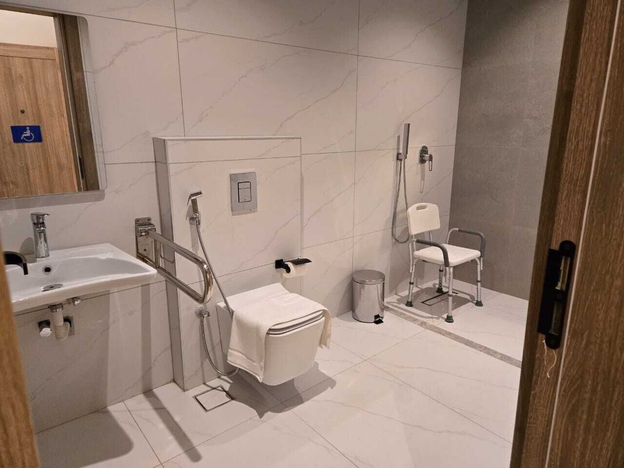 A modern bathroom with a sink, toilet, and shower area.