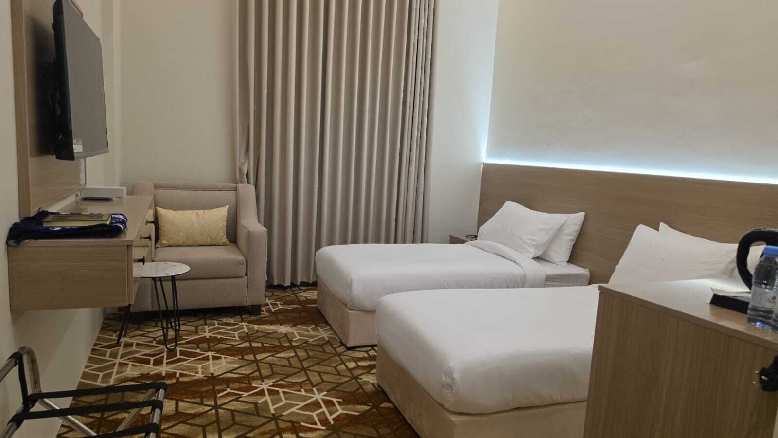 Una habitación de hotel con cama, sofá, escritorio y televisor.
