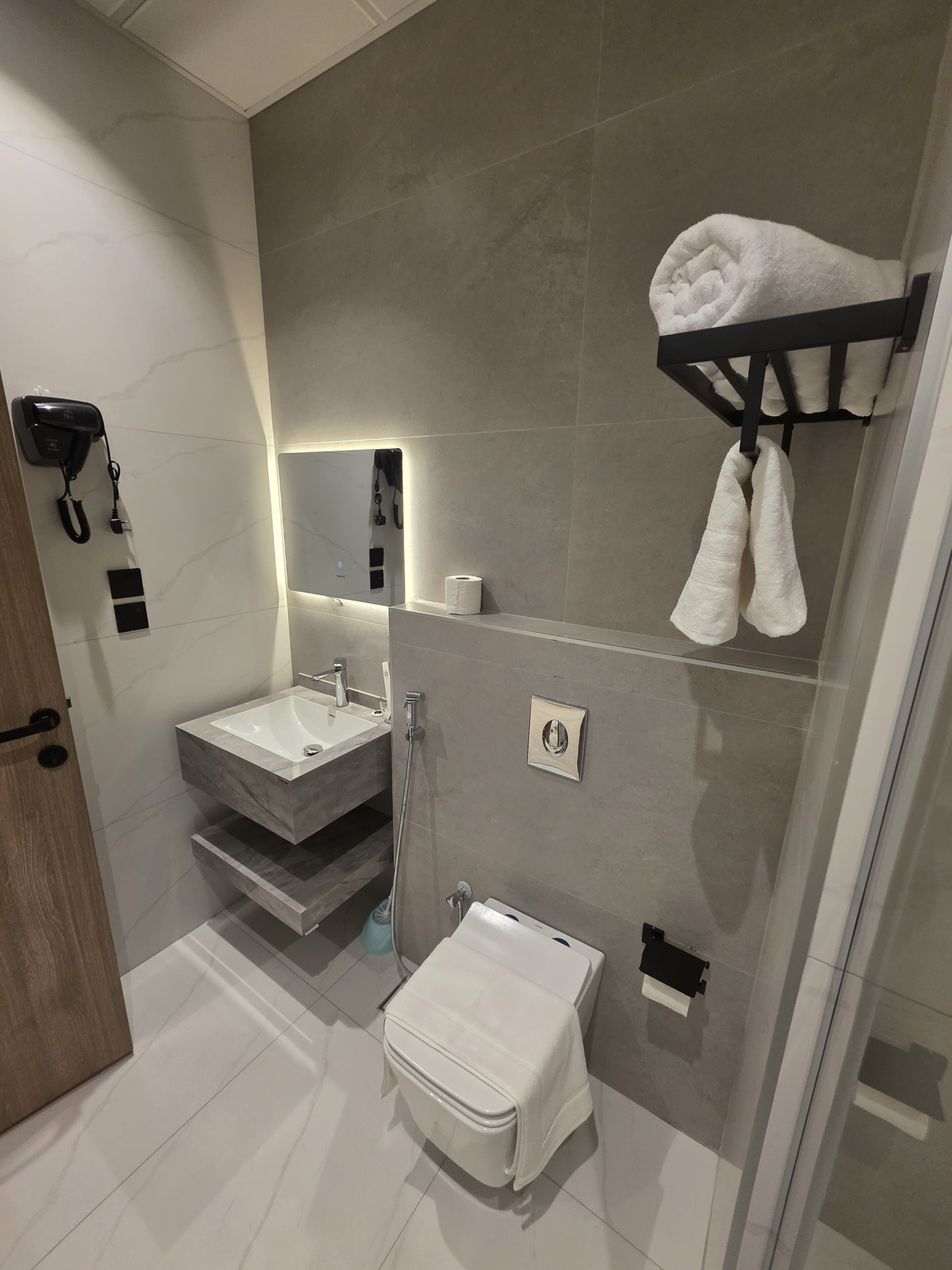 Ein modernes Badezimmer mit Waschtisch, Toilette und Duschbereich.
