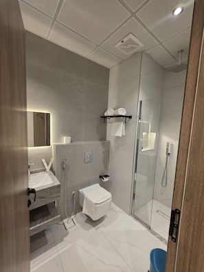 Deluxe tweepersoonskamer | Badkamer | Een douche, gratis toiletartikelen, een haardroger, handdoeken