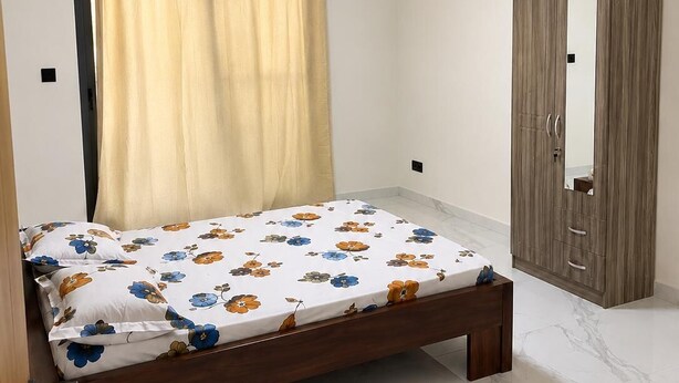 Un dormitorio con cama, aire acondicionado, armario y ventilador de techo.