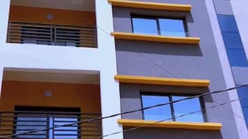 En byggnad med flera våningar, balkonger, stora fönster och en modern arkitektonisk design.