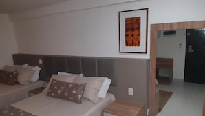 A bedroom with a bed, bedside tables, a mirror, and a framed picture on the wall.