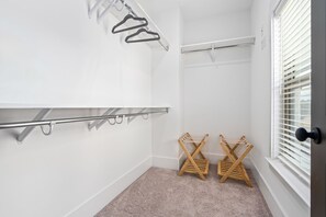 Een badkamer met een handdoekhouder, een droogrek en een raam met jaloezieën.