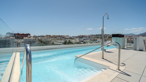A rooftop swimming pool with a clear view of the cityscape in the background. - Zaga3c - New Modern Apartment in Central Estepona (Estepona)