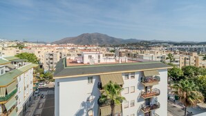 A high-rise building with balconies, a green roof, and a view of a mountain. - Zaga3c - New Modern Apartment in Central Estepona (Estepona)