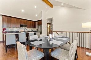 A modern kitchen with dark wooden cabinets, a stainless steel refrigerator, and a microwave. - Perfect Family Getaway: 3BR with Hot Tub and Stunning Alpine Views (Keystone)