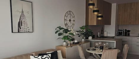 Uma sala de estar moderna com sofá, mesa de centro e área de jantar com cadeiras e mesa.