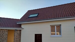Yhden kerroksen rakennus, jossa on punatiilikatto, pieni ikkuna ja ovi.