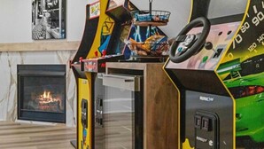 A gaming arcade with a racing theme, a fireplace, and a marble floor.
