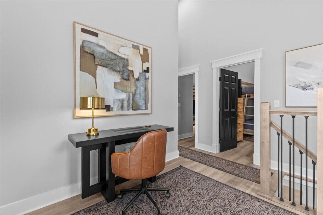 Ein modernes Interieur mit Schreibtisch, Stuhl und einem Bild an der Wand.
